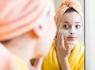 Girl applying cream on skin