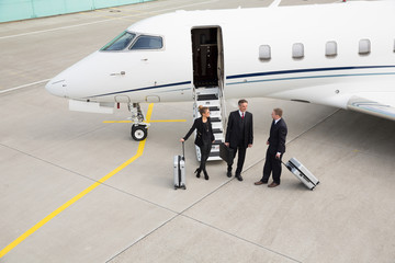 executive manager in front of corporate jet