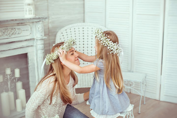 Daughter is putting a floral wreath on her mother - 84980670