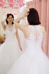 Naklejka premium Young girl tries on a wedding dress