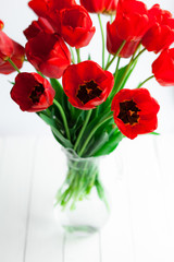 Obraz premium Red tulips on wood table closeup, selective focus