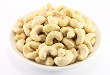 Handful of cashew nuts on a white porcelain dish