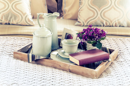 Vintage photo of decorative tray with book,tea set and flower on