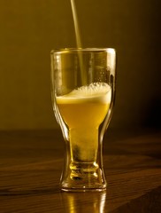 light fresh beer in glasses, on a wooden table
