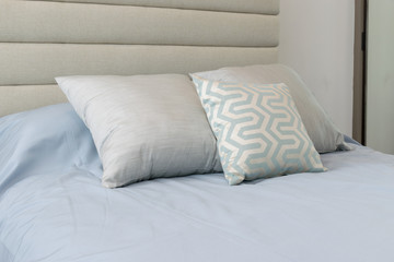 Fototapeta na wymiar Comfortable soft pillows on the light blue bed
