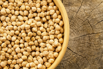 bunch of chickpeas in a bowl on old wooden background. Indian cuisine