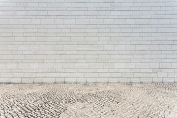 white brick wall and empty sandstone road