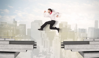 Energetic business man jumping over a bridge with gap