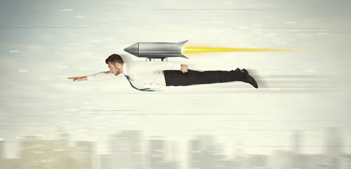 Superhero business man flying with jet pack rocket above the cit
