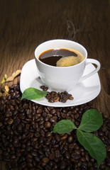 Cup of coffee with smoke on old wooden background