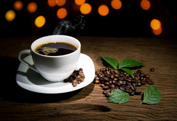 Cup of coffee with bokhe on old wooden background
