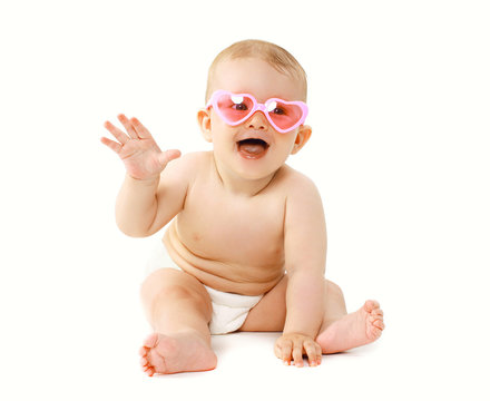 Happy laughing baby sitting in sunglasses playing and having fun