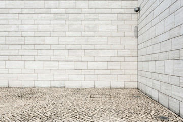 white brick wall and empty sandstone road