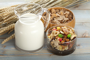 Granola with fruits and nuts and jug of milk