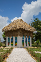 Fototapeta na wymiar ein kleines Haus mit Palmenblätter Dach und Surfbrettern