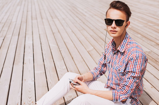 Young man using smart phone with headphones