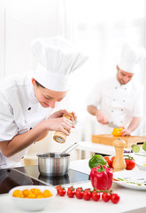 Young attractive professional chef cooking in his kitchen