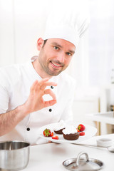 Young attractive professional chef cooking in his kitchen