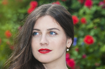 the girl in the garden on a background of rose bush