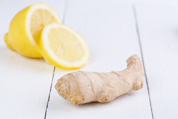 Fresh ginger and lemon on wooden table.