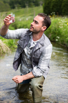 Biologist take a sample in a river in order to do some test