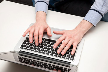 Fototapeta na wymiar Man's hands typing on laptop. Internet surfing. Programming code