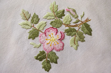 Embroidered satin stitch pink flower on cotton cloth