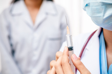 close up of doctor holding syringe for injecting the patient 