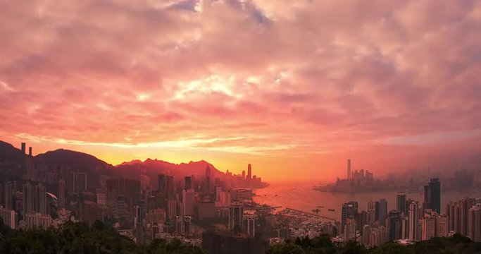 Hong Kong sunset time lapse. Scenic panoramic view of city skyline and sun rays