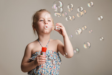 little cute girl blowing soap bubbles