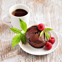Chocolate brown muffins with fresh raspberries and a cup of espresso for breakfast.