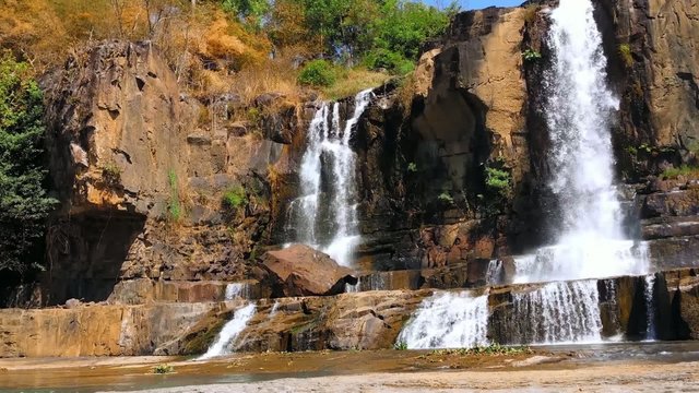 Pongour waterfall in nature national park in Dalat, Vietnam. Mountain river cascade falls in rocky terrain environment