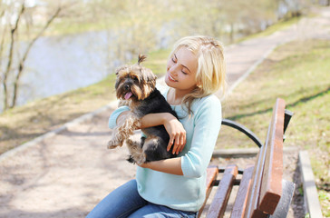 Happy young girl owner with yorkshire terrier dog walking in the