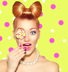 Beauty fashion model girl Eating colourful lollipop