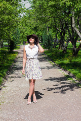 Woman with a hat is walking in the Park on a sunny day