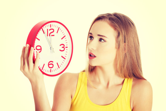 Woman In Yellow Top Holding A Clock.
