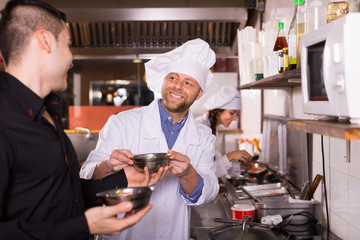 Fototapeta na wymiar Male waiter holding dishes at kitchen