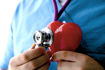 Stethoscope with heart in doctor hands, close-up