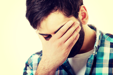Fototapeta premium Young depressed man touching his face.
