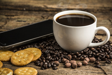 Cup of hot coffee on a old wooden table with coffee bean and  bi
