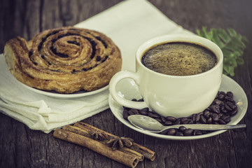 Coffee cup with a croissant on vintage wooden table