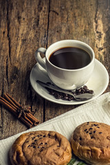 Cup of hot coffee on a old wooden table with coffee bean and  bi