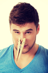 Young man with clothespin on his nose.
