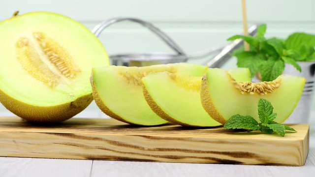 Juicy honeydew melon on a wooden table background.