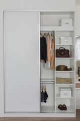 white closet with clothes and accessories
