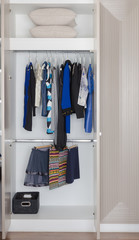 white wardrobe with clothes hanging