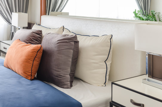 modern bedroom with orange pillow and blue blanket