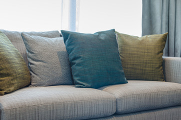group of fabric pillows on fabric sofa in living room