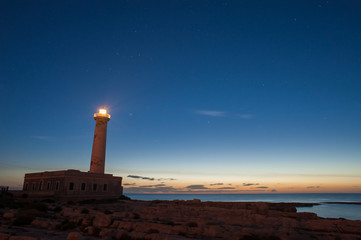 Lighthouse and starrry night before the sunrise