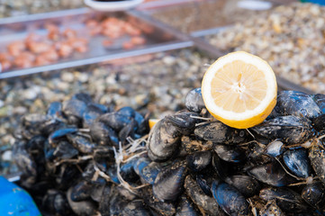 Cut in half lemon on black mussels in the public fishmarket of Catania, Sicily